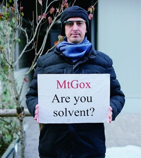 Mt.Gox比特币被盗一空后，一名受害者举牌质问“Mt.Gox，你能赔偿我们吗？”